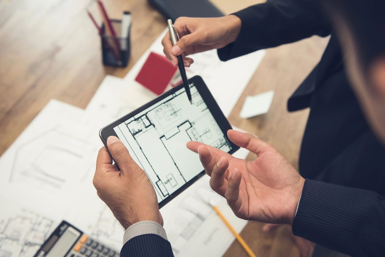 Real estate professionals reviewing floor plans
